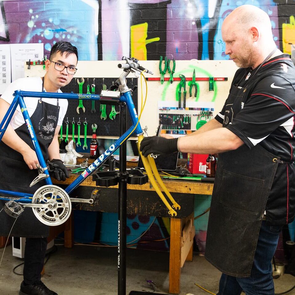 Two people repairing a bike together at the Bike Hub's volunteer hub workshop